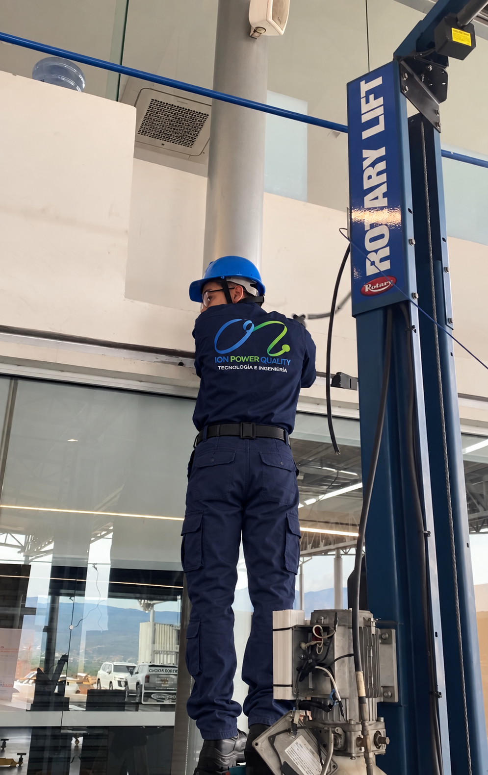 Técnico de ION Power Quality trabajando en un elevador de vehículos Rotary Lift